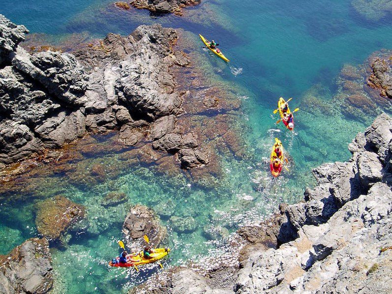 Kayaks en el mar entre rocas